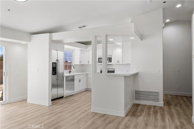 kitchen featuring white cabinets, visible vents, light countertops, stainless steel appliances, and light wood-type flooring