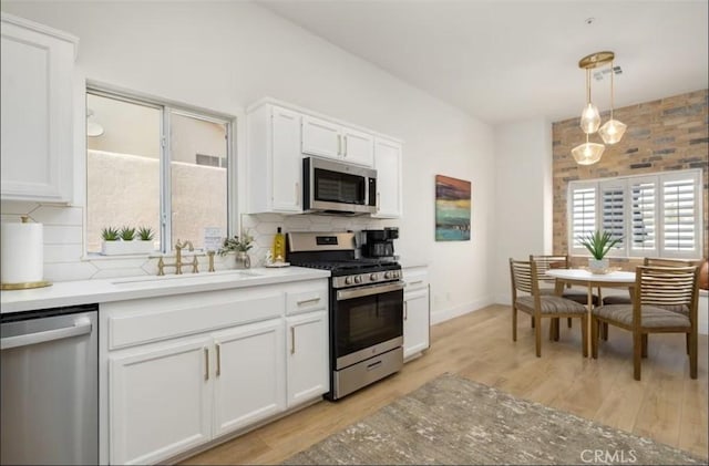 kitchen featuring a sink, white cabinets, decorative backsplash, and appliances with stainless steel finishes