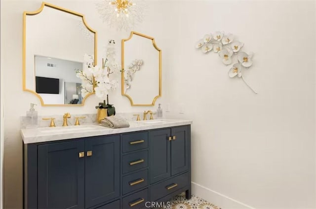 bathroom featuring baseboards, double vanity, visible vents, and a sink