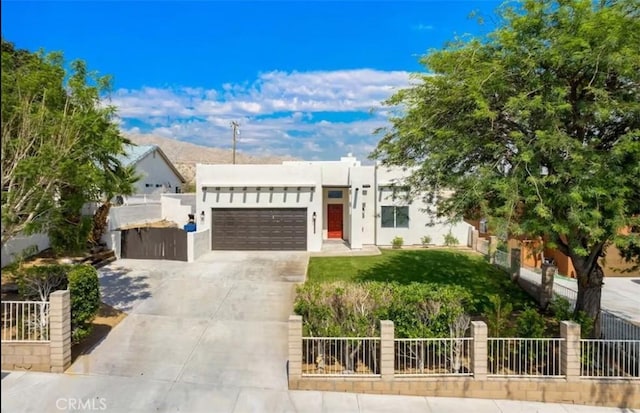 view of front facade featuring stucco siding, an attached garage, fence, and concrete driveway