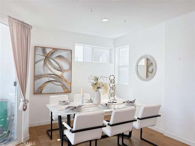 dining room with baseboards, wood finished floors, and recessed lighting
