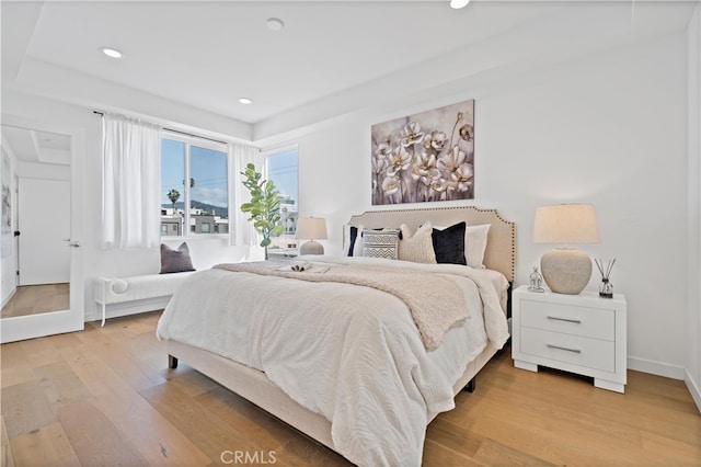 bedroom featuring baseboards, wood finished floors, and recessed lighting