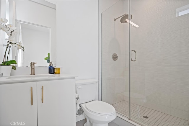 full bathroom featuring vanity, toilet, and a shower stall
