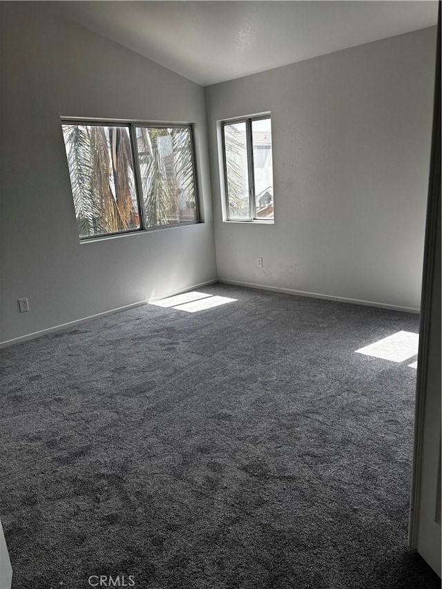 unfurnished room with baseboards, carpet floors, and lofted ceiling