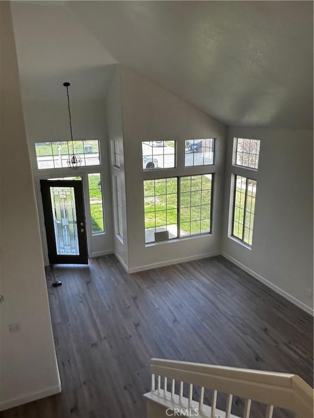 foyer featuring baseboards, high vaulted ceiling, and wood finished floors