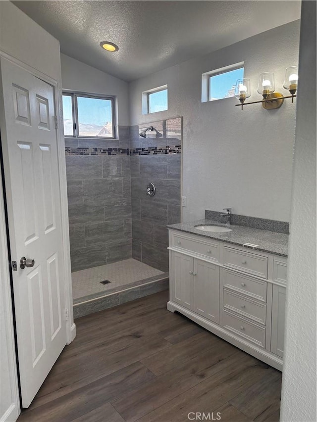bathroom with wood finished floors, walk in shower, and plenty of natural light