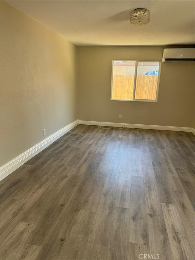 518 E 2nd St, Rialto, CA 92376 - spare room featuring an AC wall unit and dark wood-style flooring