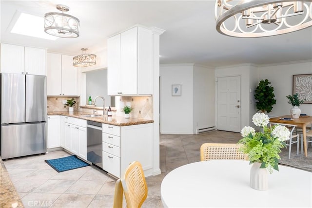 kitchen with appliances with stainless steel finishes, a sink, a chandelier, white cabinetry, and tasteful backsplash