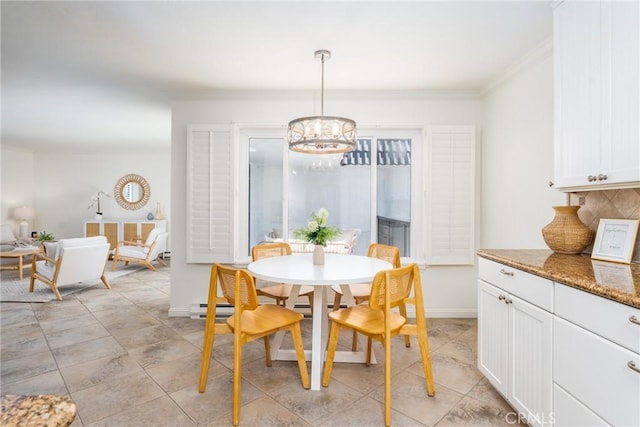 dining area with baseboards, ornamental molding, and a notable chandelier