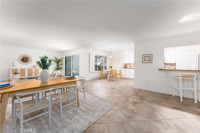 dining room featuring crown molding, baseboards, and a baseboard heating unit