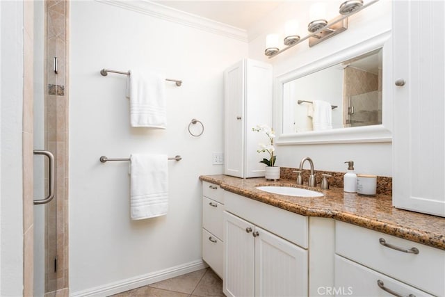 full bath featuring tile patterned flooring, vanity, baseboards, a shower stall, and ornamental molding