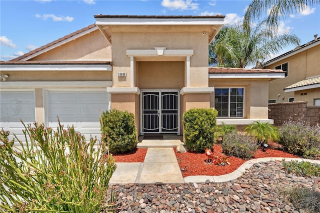 24898 Sunset Vista Ave, Menifee, CA 92584 - doorway to property with a garage and stucco siding