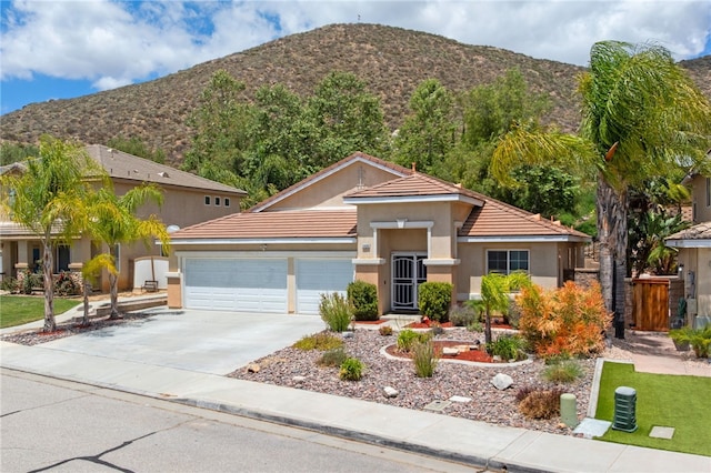 24898 Sunset Vista Ave, Menifee, CA 92584 - view of front of home with a mountain view, concrete driveway, a garage, and stucco siding