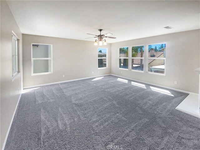 carpeted empty room with baseboards and ceiling fan