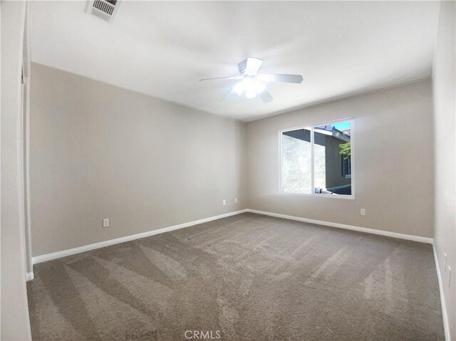 carpeted spare room featuring a ceiling fan, baseboards, and visible vents