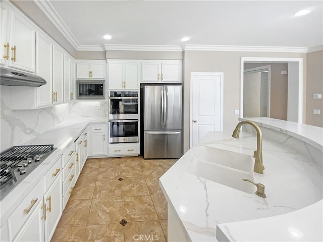kitchen featuring decorative backsplash, ornamental molding, stainless steel appliances, and white cabinets