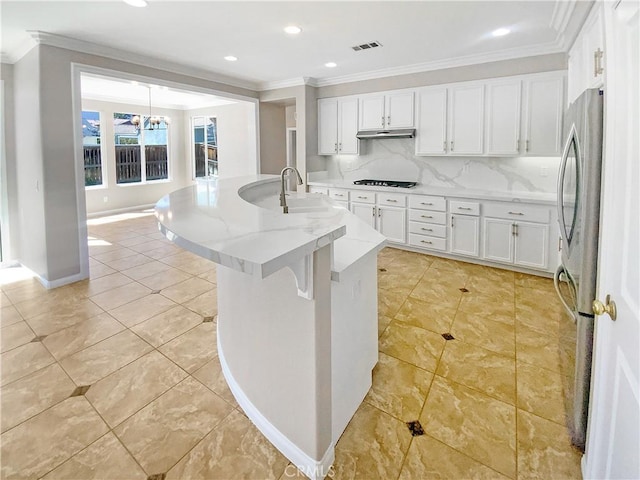kitchen featuring freestanding refrigerator, ornamental molding, and visible vents