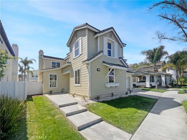 exterior space with driveway, a garage, fence, and a front lawn