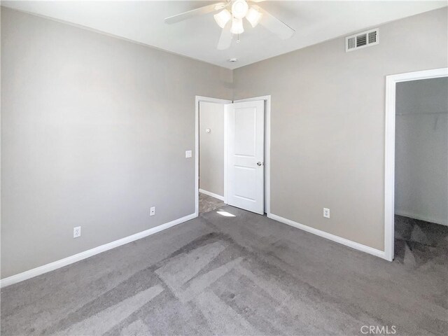 unfurnished bedroom featuring baseboards, visible vents, a spacious closet, and carpet