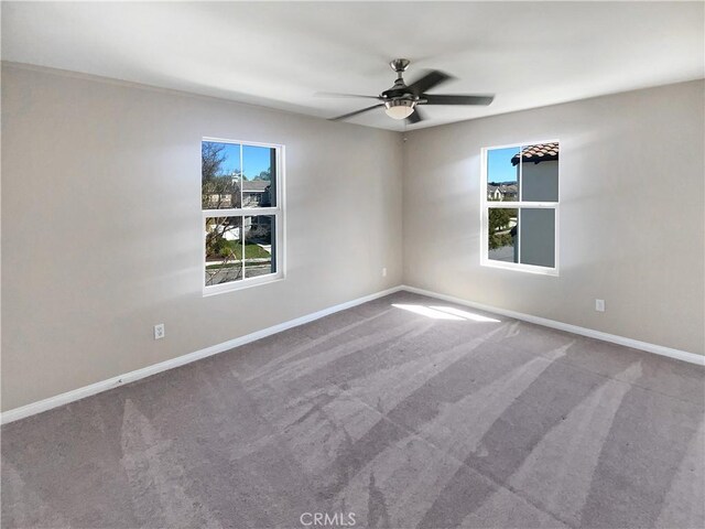 carpeted empty room with baseboards and ceiling fan