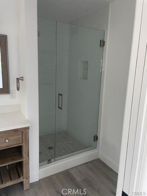 12472 Woodlawn Ave, Tustin, CA 92780 - bathroom featuring vanity, a stall shower, baseboards, and wood finished floors