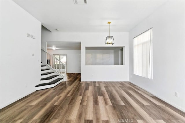 595 Casey Ct, Colton, CA 92324 - unfurnished living room featuring wood finished floors, a chandelier, stairway, and baseboards