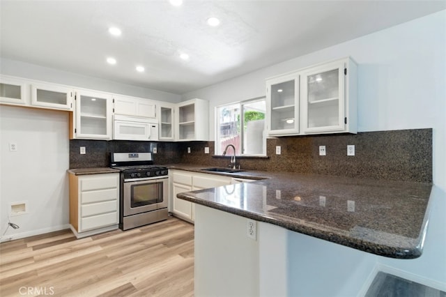 595 Casey Ct, Colton, CA 92324 - kitchen with gas stove, white microwave, a sink, a peninsula, and light wood finished floors