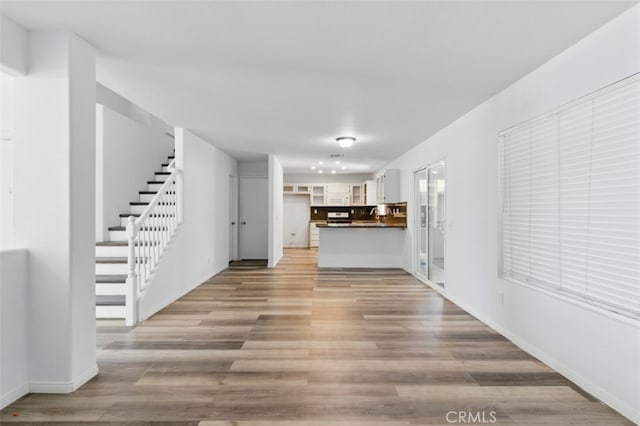 595 Casey Ct, Colton, CA 92324 - unfurnished living room featuring stairway, light wood finished floors, and baseboards