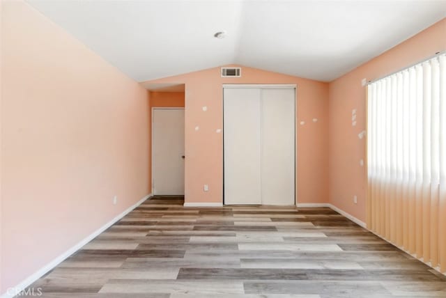 595 Casey Ct, Colton, CA 92324 - unfurnished bedroom with light wood-style flooring, lofted ceiling, a closet, and baseboards