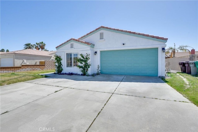 82235 Calico Ave, Indio, CA 92201 - mediterranean / spanish-style home with concrete driveway, fence, and stucco siding