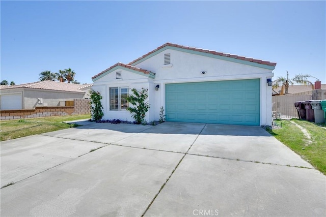 82235 Calico Ave, Indio, CA 92201 - mediterranean / spanish home featuring concrete driveway, stucco siding, a tile roof, and a garage