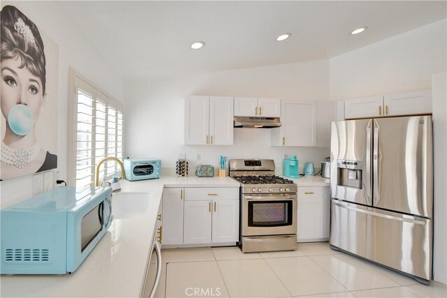 82235 Calico Ave, Indio, CA 92201 - kitchen with appliances with stainless steel finishes, under cabinet range hood, light countertops, white cabinets, and recessed lighting