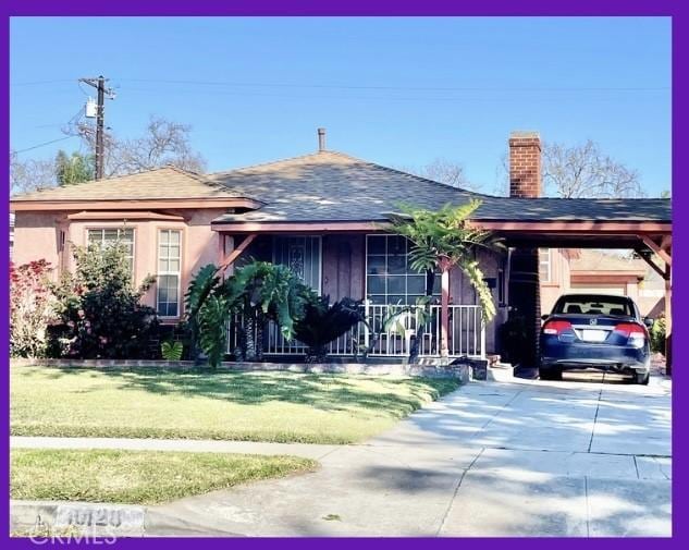 single story home with a front yard, a chimney, driveway, a carport, and roof with shingles