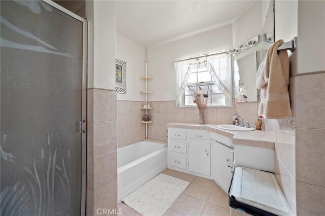 full bath with a shower stall, a washtub, tile walls, vanity, and tile patterned flooring