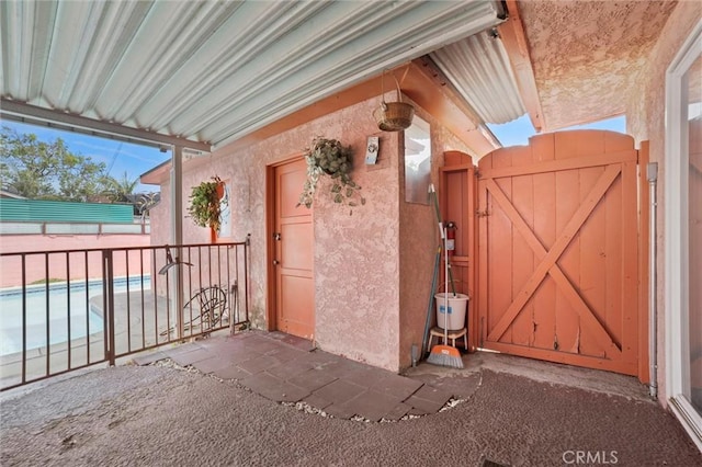 exterior space with stucco siding, fence, a gate, and a fenced in pool