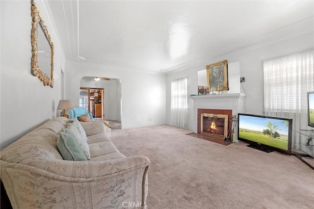 living room featuring crown molding, carpet floors, and a fireplace