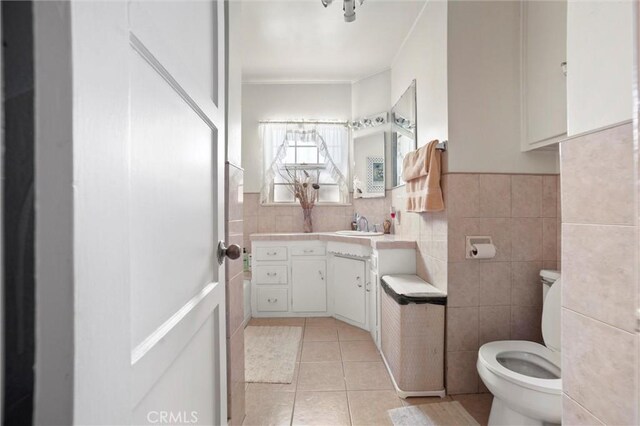 bathroom featuring tile walls, vanity, tile patterned floors, toilet, and ornamental molding