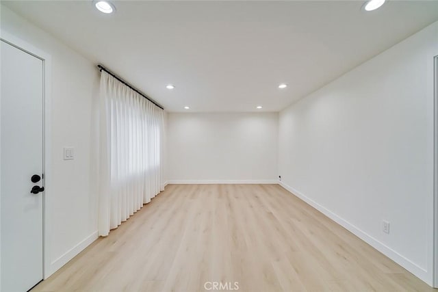 spare room with light wood-type flooring, baseboards, and recessed lighting