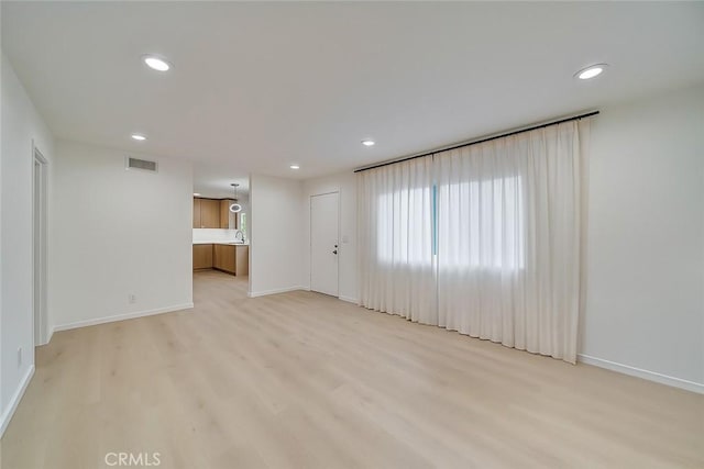 spare room featuring baseboards, visible vents, recessed lighting, and light wood finished floors