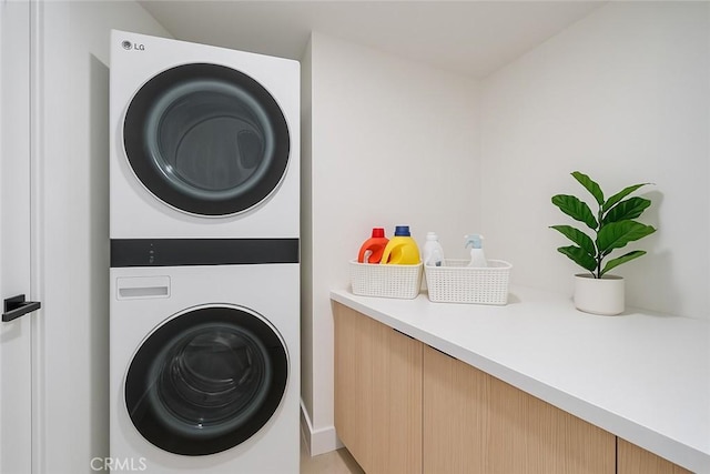 laundry area featuring stacked washer / drying machine and laundry area