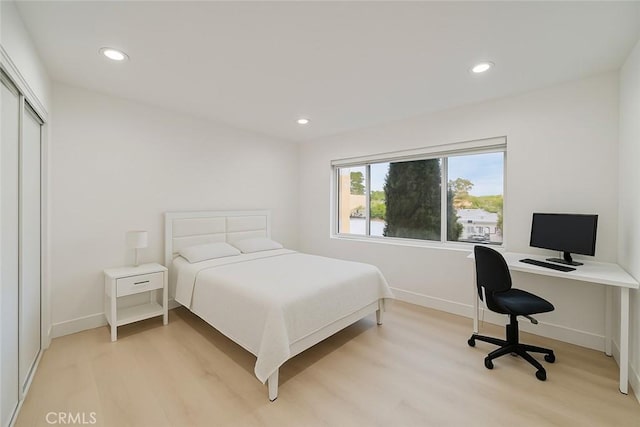 bedroom with baseboards, a closet, recessed lighting, and light wood-type flooring