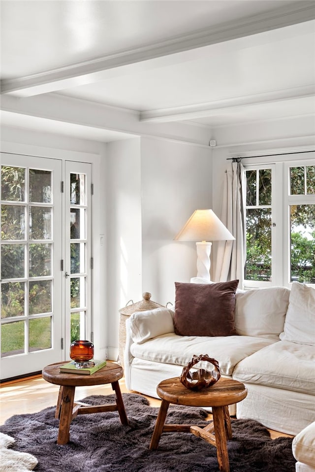 living room featuring wood finished floors, crown molding, and beam ceiling