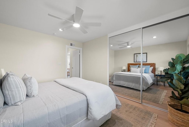 bedroom with visible vents, a ceiling fan, a closet, and wood finished floors