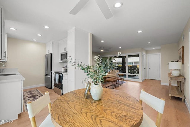 dining room featuring light wood-style floors, baseboards, a ceiling fan, and recessed lighting