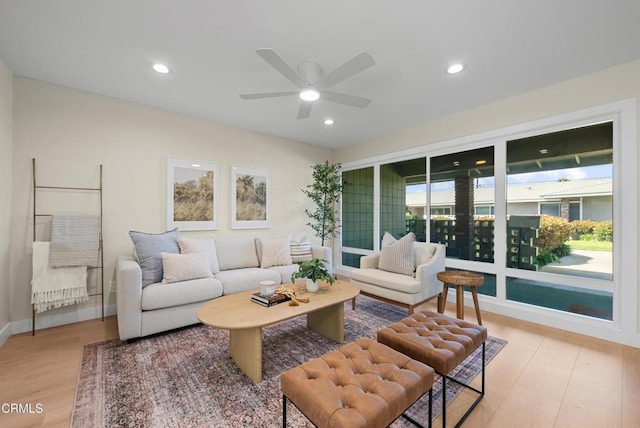 living room featuring light wood-type flooring, a ceiling fan, and recessed lighting