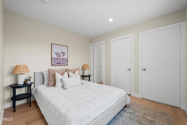 bedroom featuring baseboards, light wood finished floors, and recessed lighting