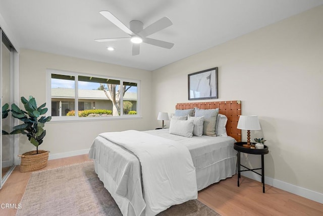 bedroom with wood finished floors, ceiling fan, and baseboards