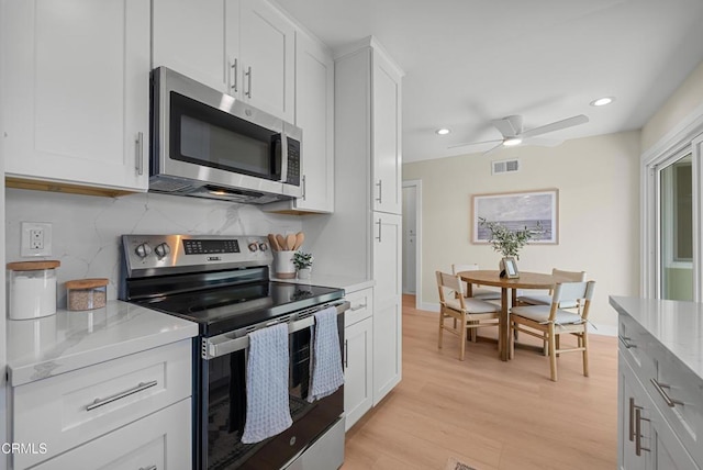 kitchen with tasteful backsplash, a ceiling fan, visible vents, appliances with stainless steel finishes, and light wood finished floors