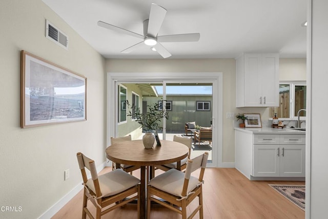 dining room with visible vents, ceiling fan, light wood-type flooring, and baseboards