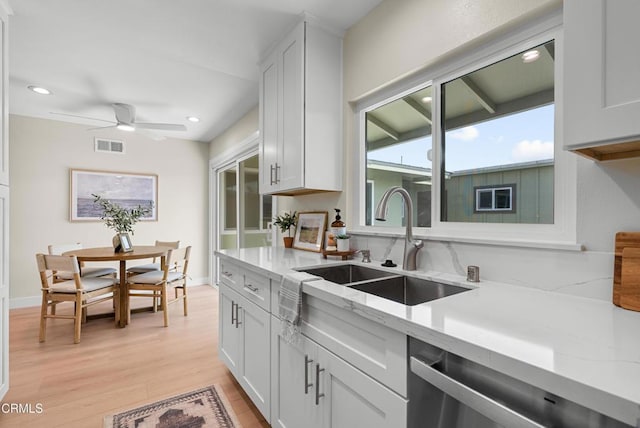 kitchen featuring light wood-style flooring, visible vents, a sink, a ceiling fan, and stainless steel dishwasher
